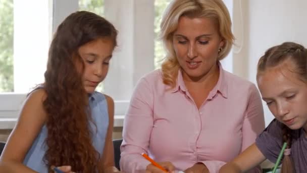 zwei junge Mädchen arbeiten mit ihrem Lehrer in der Schule an einem Kunstprojekt - Filmmaterial, Video
