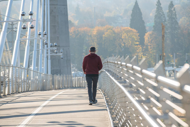 Взрослый мужчина идет по металлическому мосту
. - Фото, изображение