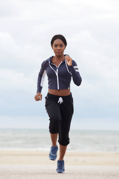 Portrait complet de la femme afro-américaine en bonne santé courant sur la plage
 - Photo, image