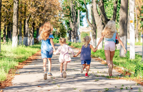 Досить усміхнені маленькі дівчата бігають разом
 - Фото, зображення