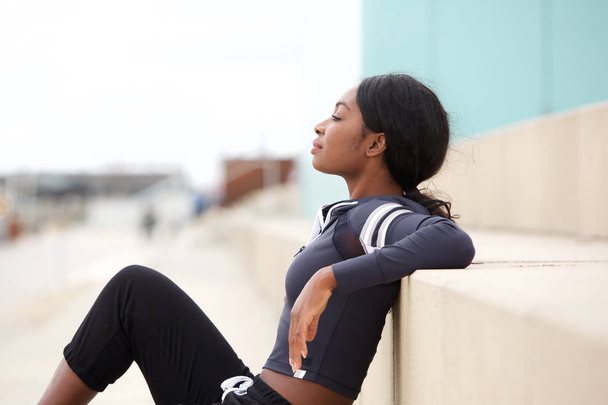Portrait latéral de jeune femme sportive afro-américaine en forme relaxant à l'extérieur
 - Photo, image
