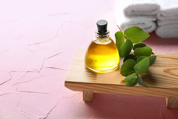 Botella de aceite esencial de eucalipto sobre soporte de madera
 - Foto, imagen