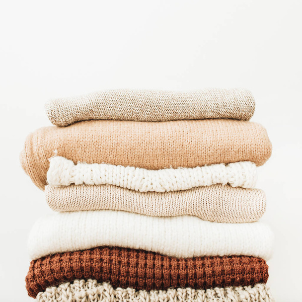Woolen sweaters and pullovers stack on white background. Woman fashion clothes on white background. - Photo, Image