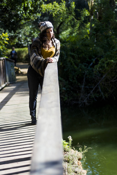 Beautiful woman on a wooden bridge in a park - Foto, Imagen
