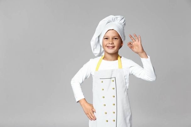 Cute little chef on grey background - Valokuva, kuva