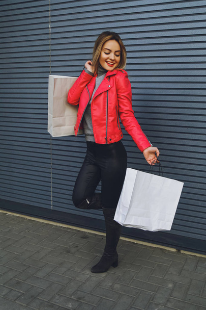 Young beautiful blonde girl with purchases, packages after shopping - Foto, Imagem