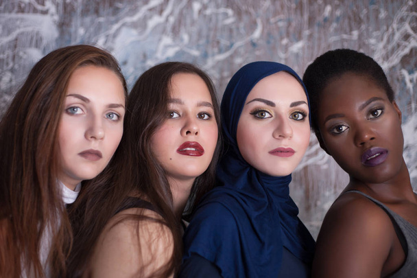 Retrato de cuatro chicas con diferente color de piel y nacionalidad en el estudio
. - Foto, imagen