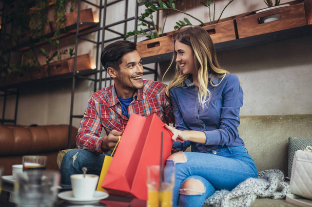 Jeune couple jouissant dans un café moderne après avoir fait du shopping
.  - Photo, image