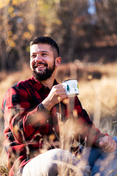 自然の中のコーヒーのカップを楽しむ男 - 写真・画像