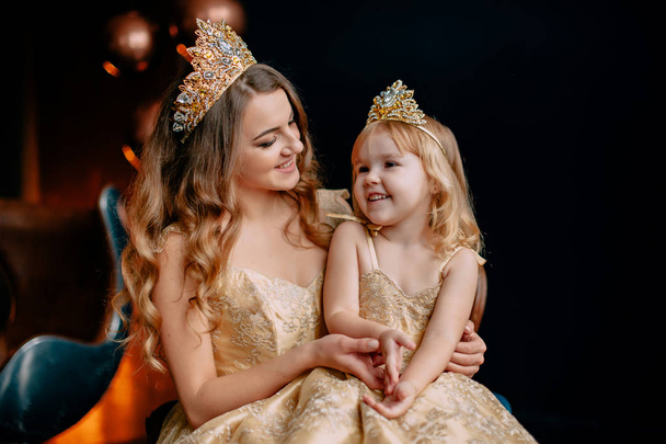 portrait of young mother and little daughter in luxurious dresses - Foto, afbeelding