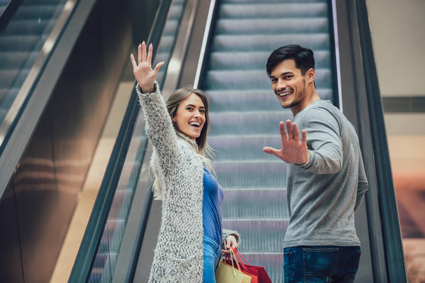 glückliches junges Paar beim Einkaufen und Halten von Taschen - Foto, Bild