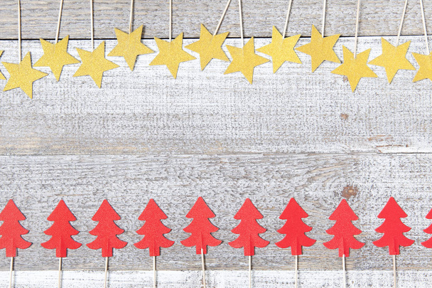 Home made decorations, golden stars and red Christmas trees on white wooden background. Retro style - Photo, Image
