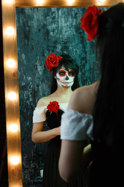 Picture of zombie woman with white face , red flower on her head - Foto, immagini