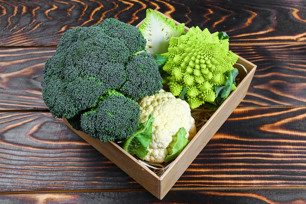 Verschillende van kool broccoli bloemkool Romanesco in de doos. Geassorteerde kool op houten achtergrond. Platte lay. - Foto, afbeelding