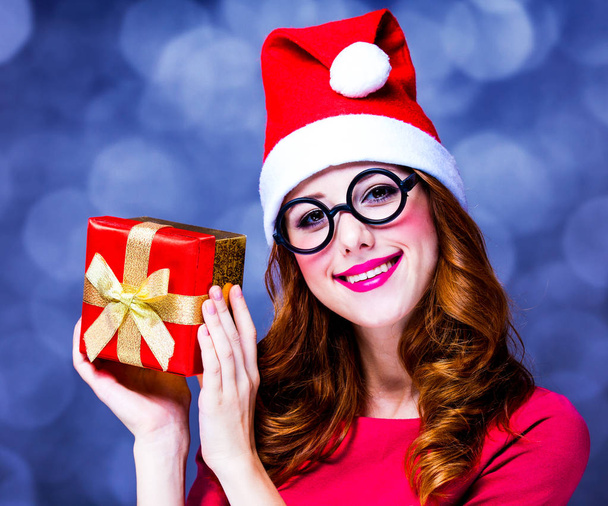 κορίτσι με κόκκινο φόρεμα και καπέλο με το πλαίσιο δώρο Χριστουγέννων - Φωτογραφία, εικόνα