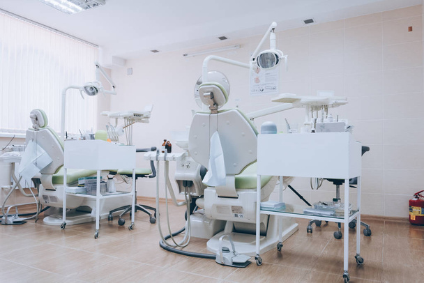 Stomatology interior of dental clinic with professional chair. Dentistry, medicine, medical equipment and stomatology concept. White tone. - Photo, Image