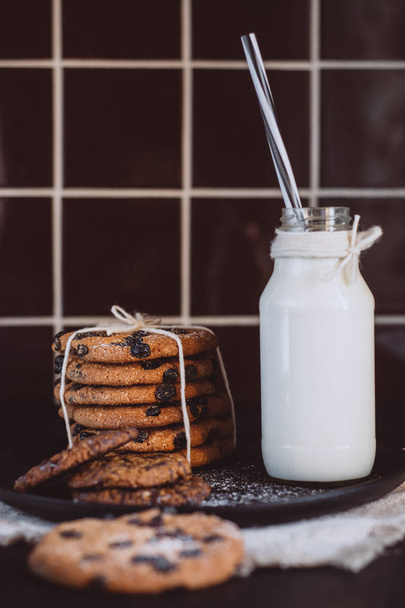 Glass with fresh milk and homemade chocolate chips cookies over a in the kitchen. Breakfast  - Фото, изображение