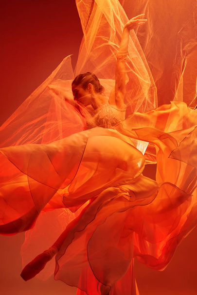 Ballerine. Jeune danseuse de ballet gracieuse dansant sur un studio rouge. Beauté du ballet classique
. - Photo, image