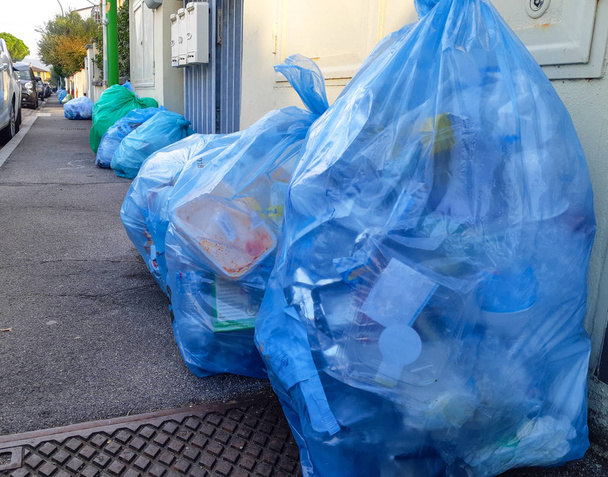 Day withdrawal of the bags with plastic. Separate collection for recycling in Italy. - Photo, Image