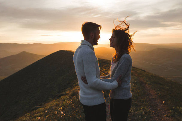 Onnellinen pari halaus ja suudella auringonlaskun witn hämmästyttävä vuoristomaisema. Lämmin ilta auringon valo
 - Valokuva, kuva