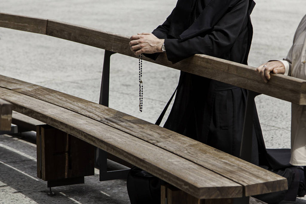 Manos de un sacerdote con la cruz orando, detalle de la creencia y la fe cristiana - Foto, imagen
