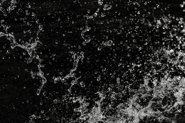 Wassertropfen in der Luft auf dunklem Bokeh-Hintergrund - Foto, Bild