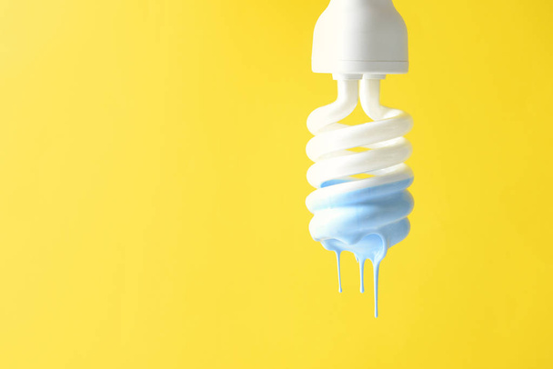 Paint dripping from light bulb on color background - Photo, Image