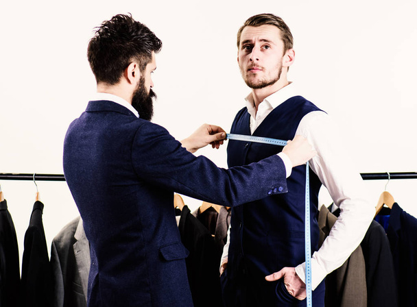 Businessman, client stand near hanger with suits while tailor working. - Foto, Imagem