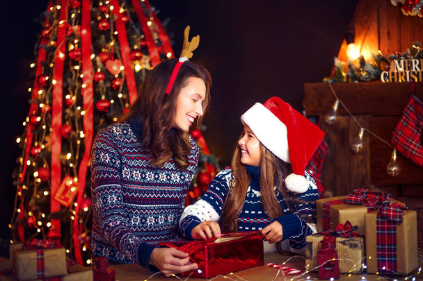 a happy family mother and child pack Christmas gifts - Foto, imagen