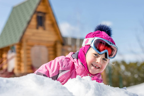 雪の野外で遊ぶ楽しいスポーツ冬ジャケット、スキー用ゴーグルに白人の女の子はかわいいそびれたの肖像画。冬の休暇や休日のコンセプトです。子どもたちの野外活動. - 写真・画像