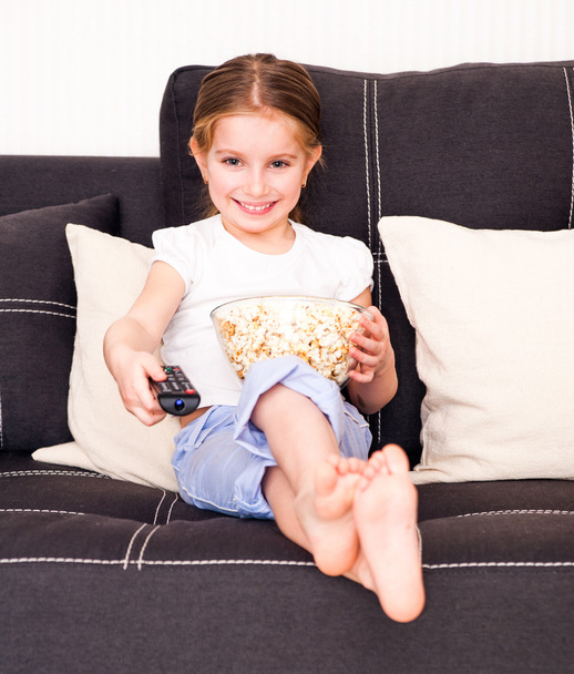 Маленькая девочка смотрит телевизор
 - Фото, изображение
