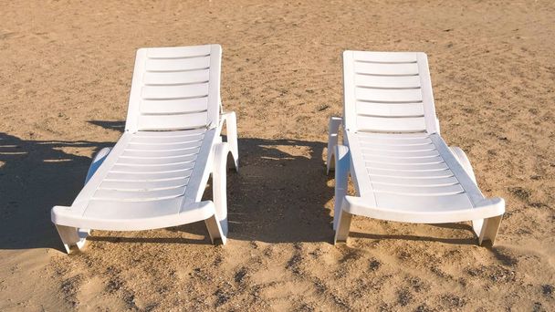 Two sunlongers on the sand beach in summer. - Фото, зображення