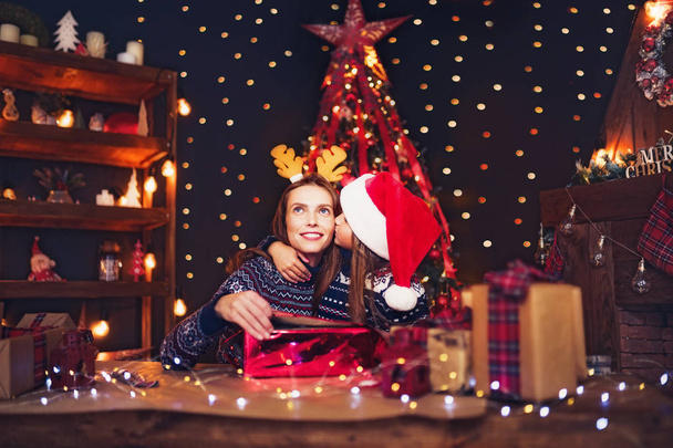 a happy family mother and child pack Christmas gifts - Photo, image