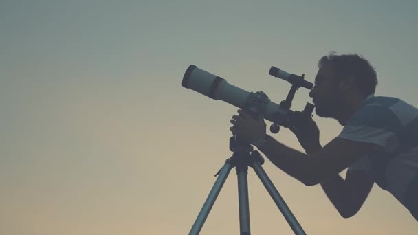A fiatalember kiigazítására és keresi csillagászati távcső este. - Felvétel, videó