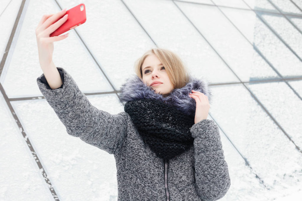 Selfie time, Young funky blogger is making photo for her social networks page. Young happy woman taking selfie. Cold sunny weather. Woman winter concept. - Фото, зображення