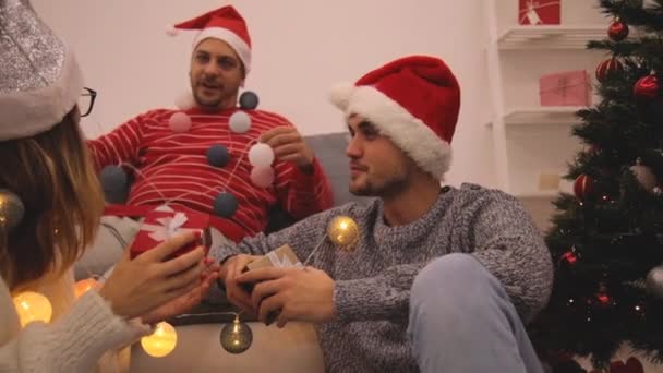 Three friends sharing Christmas / New Year's eve  presents. - Záběry, video