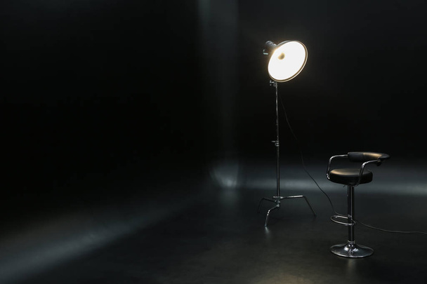 Professional lighting equipment with chair on dark background - Valokuva, kuva