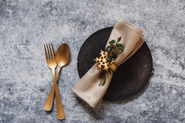 Joulun kattaus, kultainen ruokailuvälineet ja nandinat, grunge-pöydällä. Loma-ateria
 - Valokuva, kuva