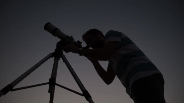 Чоловік дивиться на зірки з телескопом вночі
. - Кадри, відео