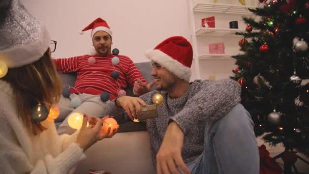 Three friends sharing Christmas / New Year's eve  presents. - Imágenes, Vídeo