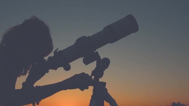 Mujer joven mirando a través del telescopio astronómico en la noche
. - Metraje, vídeo