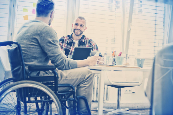 Handicap businessman discussing with colleague in creative office - Foto, immagini