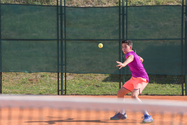 Young tennis player hitting the ball - Фото, зображення