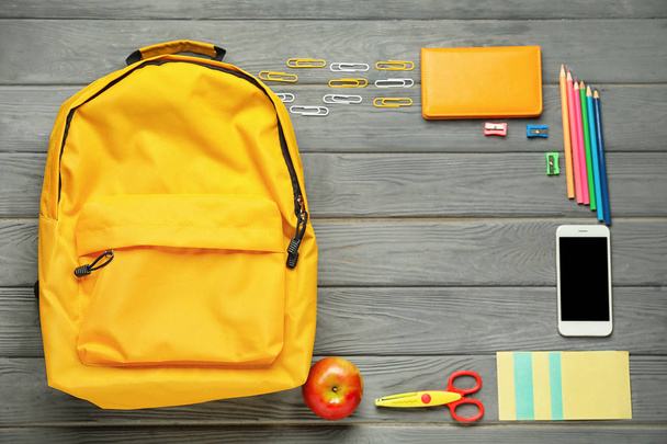 Composition avec sac à dos et papeterie scolaire sur fond bois, vue de dessus
 - Photo, image