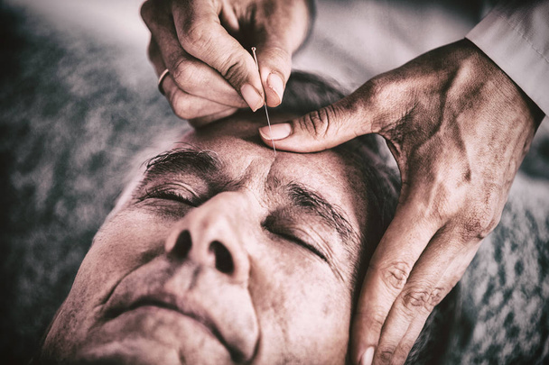 Senior man receiving head massage from physiotherapist in clinic - Fotografie, Obrázek