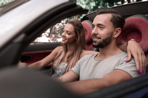 close up. a loving couple traveling in a convertible car - Фото, изображение