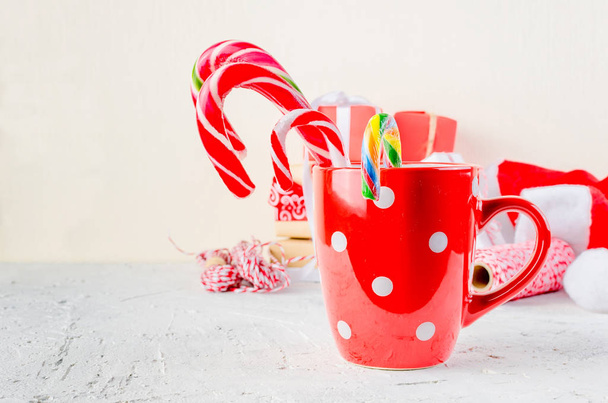 Red cup with marshmallows and candy stick, many gifts on the white background. card Holiday Concept. copy space, - Foto, Bild