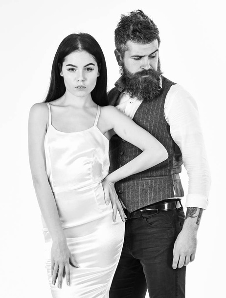 Couple in love, bride and groom in elegant clothes, white background. Wedding concept. Woman in wedding dress and man in vest. Bearded hipster with attractive bride dressed up for wedding ceremony - Foto, Imagem
