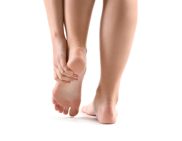 Žena trpí bolestí v noze na bílém pozadí - Fotografie, Obrázek