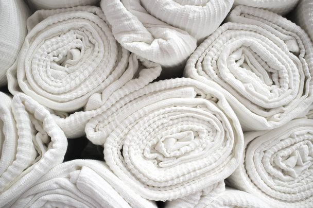Montones de colchas de algodón blanco enrollado. Primer plano.
 - Foto, Imagen
